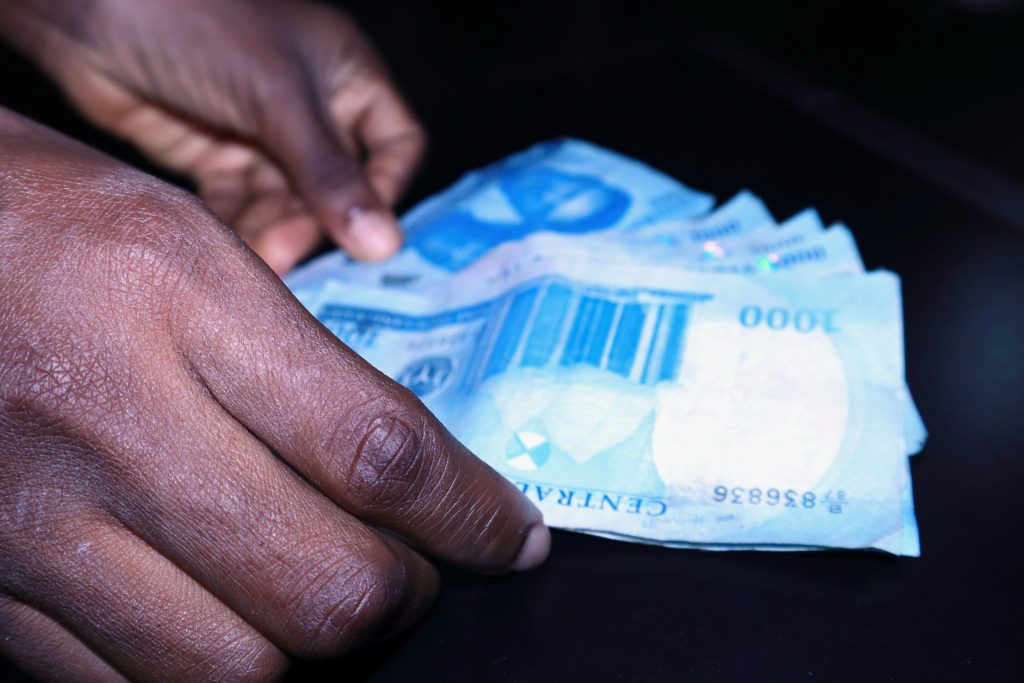 Naira banknotes in hand, illustrating how the 2026 exchange rate affects diaspora property buyers sending money to Nigeria