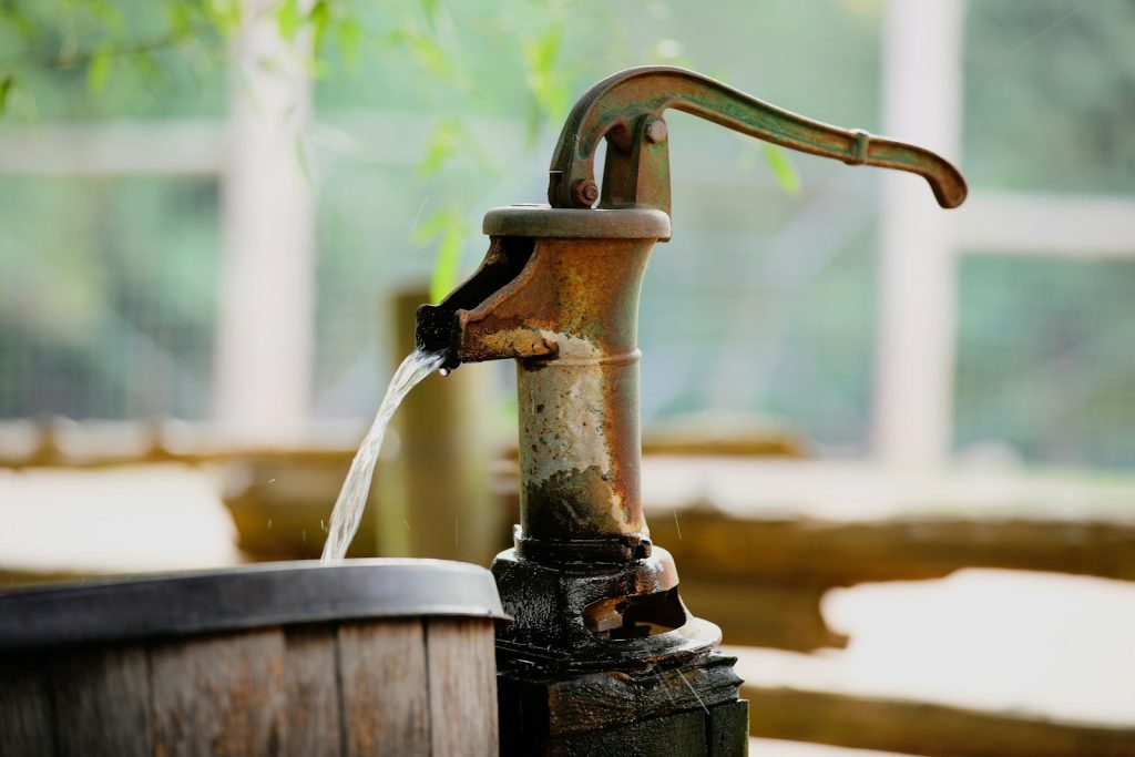 Hand water pump drawing groundwater from a borehole at a Nigerian residential compound, 2026