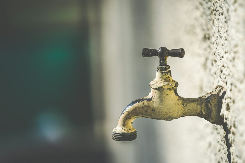 Clean water flowing from a tap, the payoff of a home borehole and water system in Nigeria
