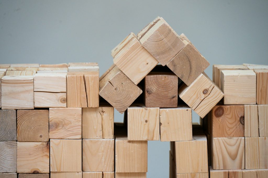 Wooden blocks assembled into the shape of a house, illustrating fractional co-ownership of Nigerian real estate in 2026
