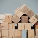 Wooden blocks assembled into the shape of a house, illustrating fractional co-ownership of Nigerian real estate in 2026