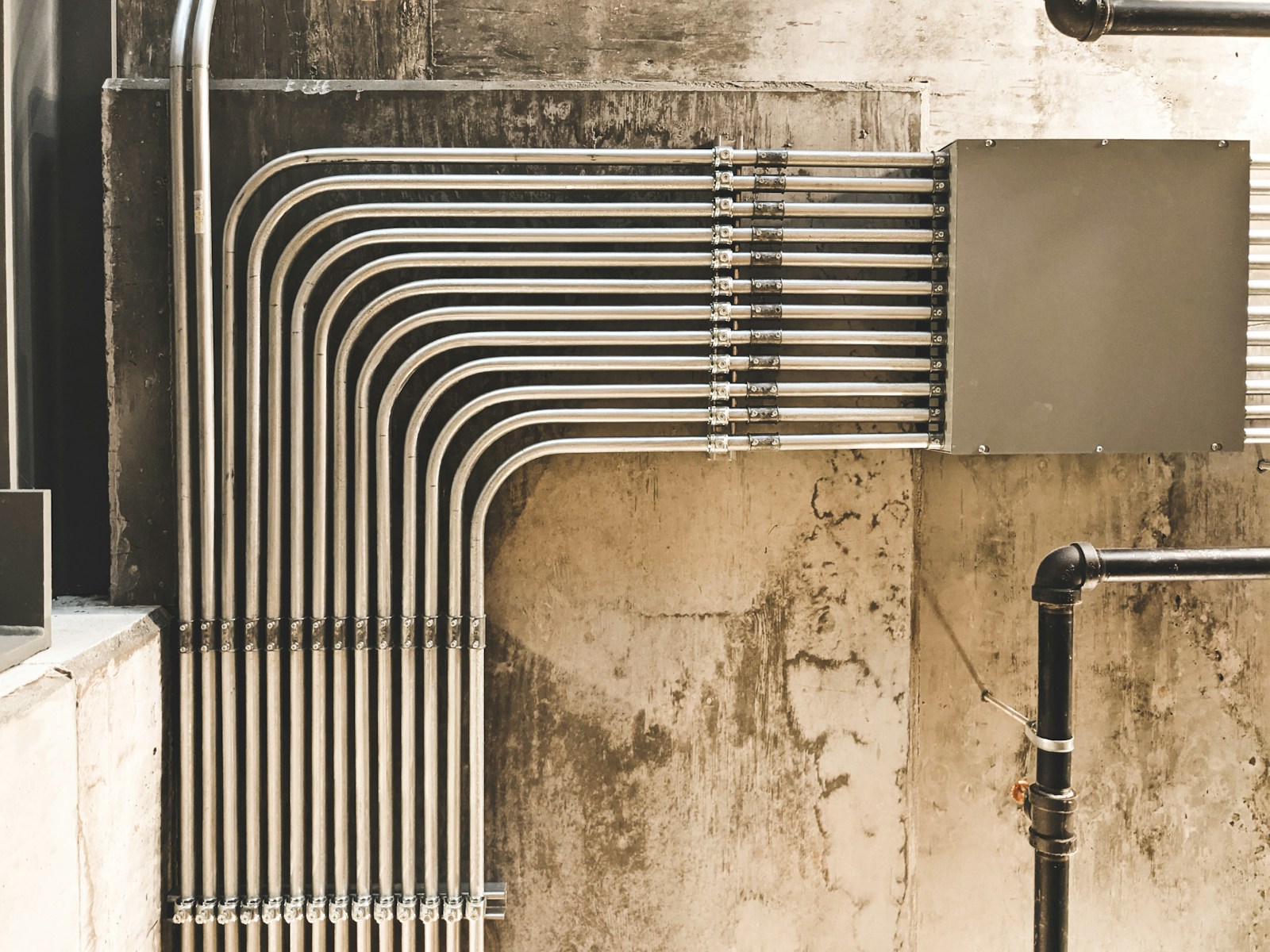 Surface electrical conduit and wiring on a concrete wall during a house installation, illustrating wiring costs in Nigeria in 2026