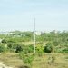 Open plot of land with houses in the background on the outskirts of Abuja, Nigeria, illustrating where to buy land by budget in 2026
