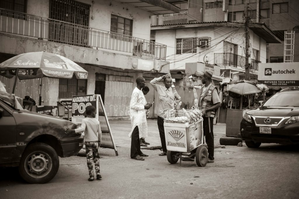 A busy Lagos street lined with small lock-up shops, illustrating the cost of building a shop in Nigeria in 2026