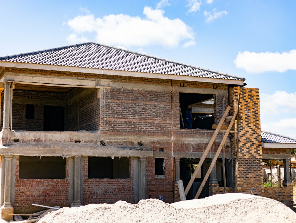 Two-storey duplex under construction in Nigeria, block walls and tiled roof, 2026