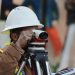 A surveyor's level standing on open land, illustrating the land verification checks that prevent costly buying mistakes in Nigeria