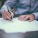 A property contract and pen on a desk, illustrating Nigerian land titles — C of O, Gazette, excision and Governor's Consent explained for 2026