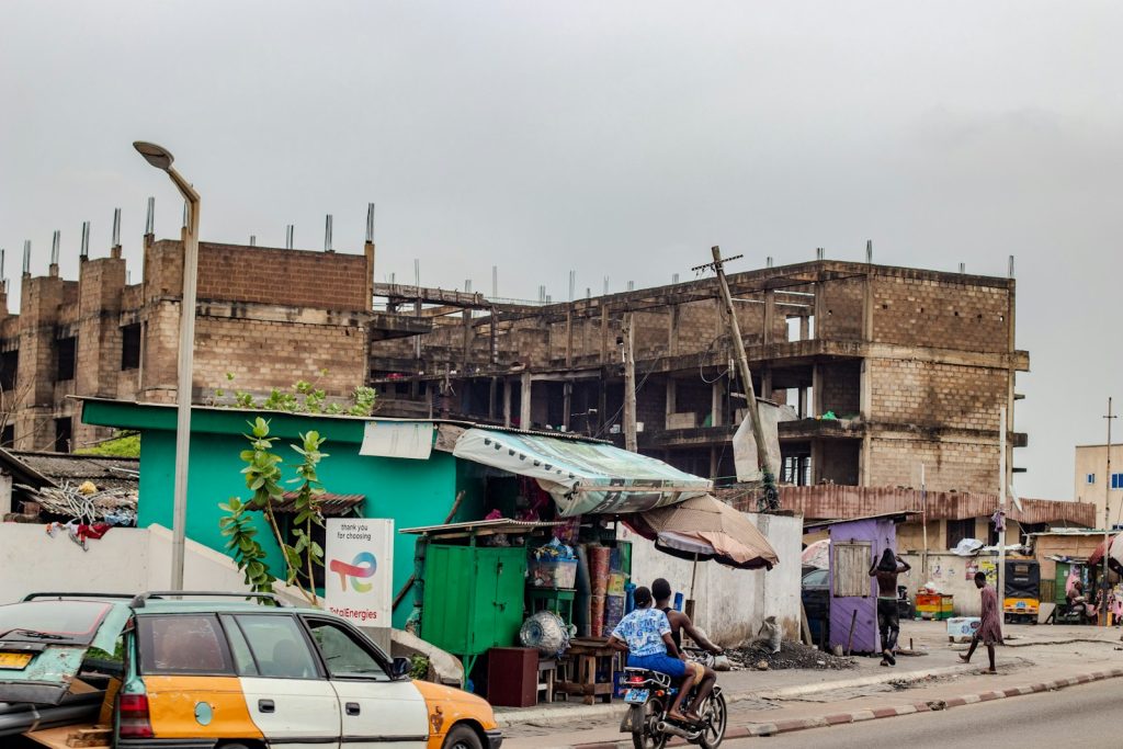 Unfinished buildings along a busy street, illustrating Nigeria's 2026 off-plan housing escrow and developer-licensing reforms