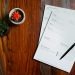 Property documents and a pen on a wooden desk, illustrating remote verification of Nigerian land titles from abroad