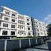 Side view of the Ikeja GRA apartment building, Lagos, showing the full run of balconies across four floors and the neighbouring development