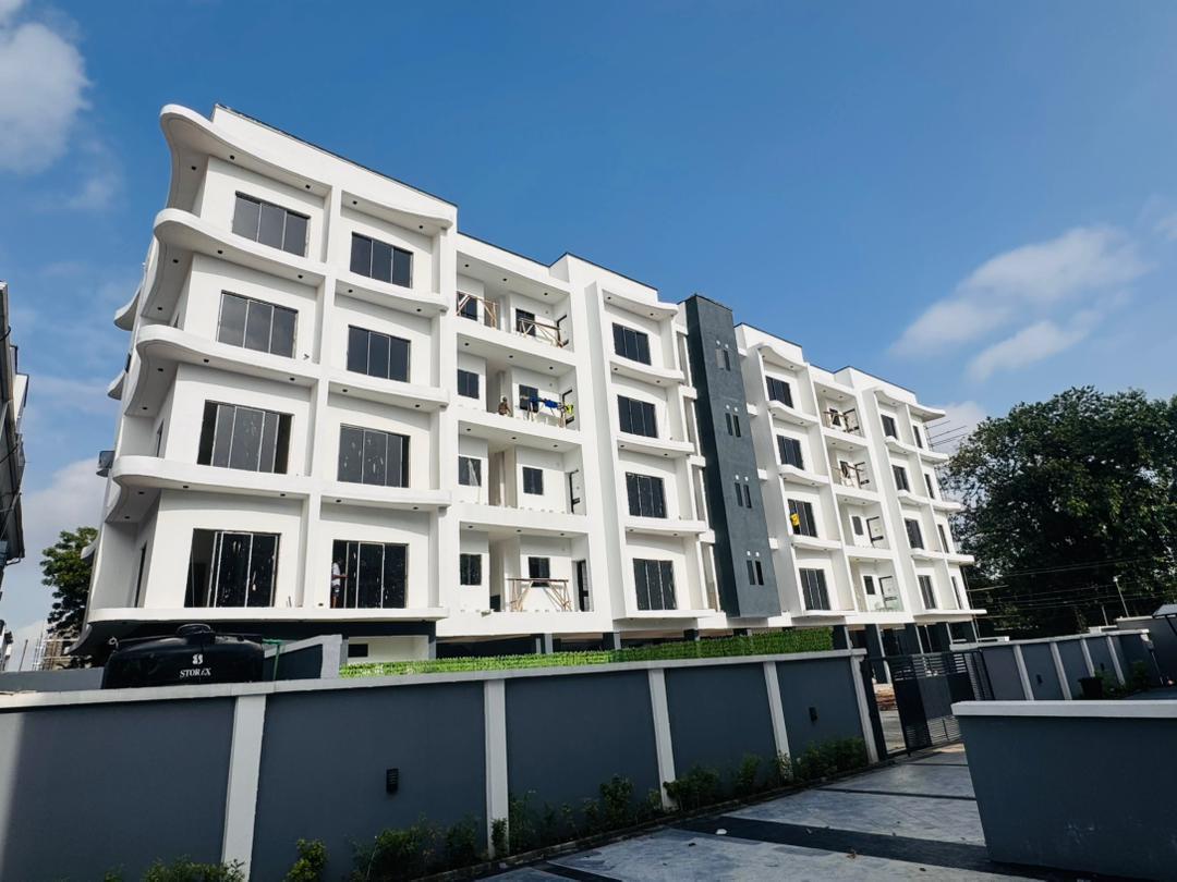 Side view of the Ikeja GRA apartment building, Lagos, showing the full run of balconies across four floors and the neighbouring development