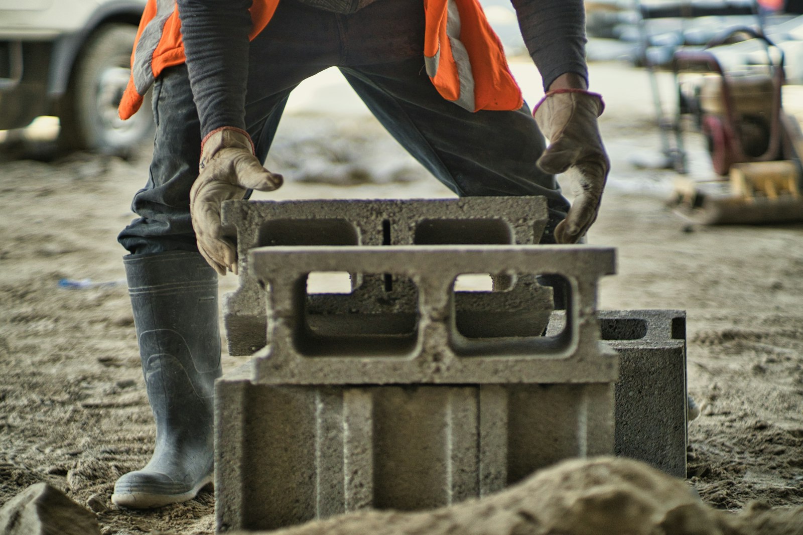 A worker carrying hollow blocks on a house construction site