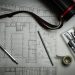 A land survey plan with drafting pencils and a ruler, representing charting and title verification for Nigerian land, 2026