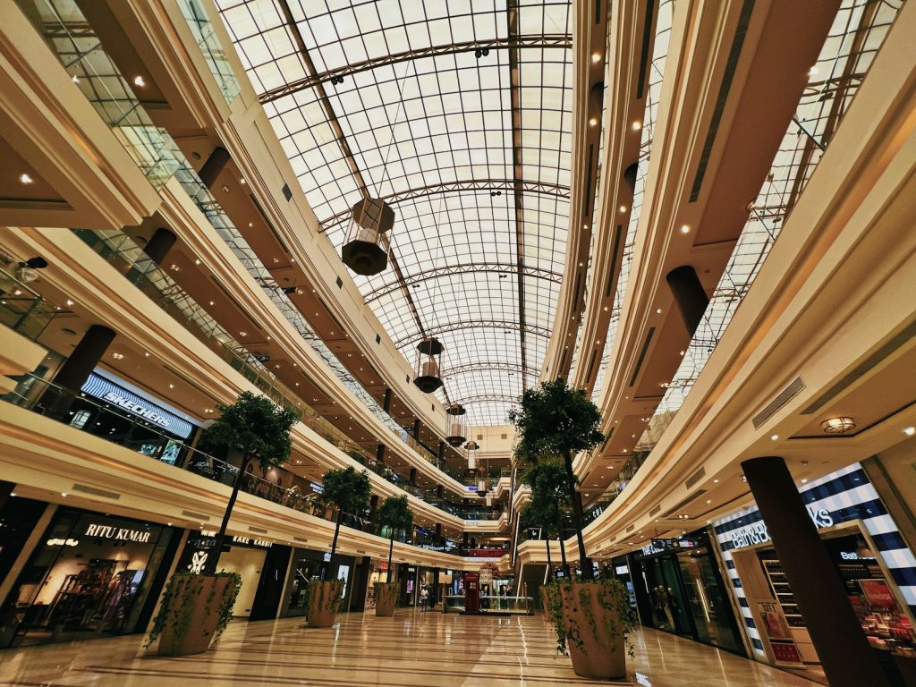 Interior atrium of a large modern shopping mall with a glass ceiling