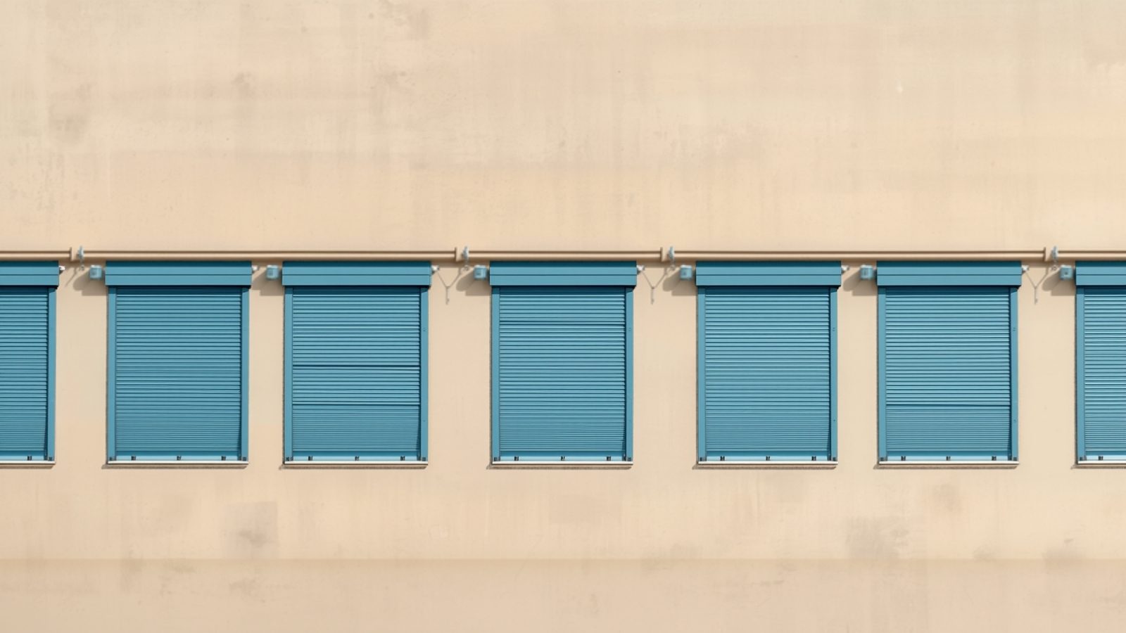 Illustration of a row of lock-up units with blue roller shutters